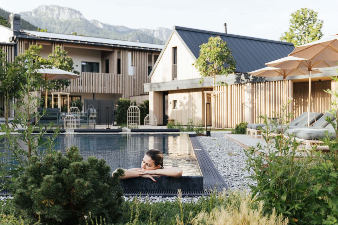 Cluster of modern Alpine architecture, around a an outdoor pool |Agrad Chalets | Luxury design and Architecture in Chiemsee, Bavaria, Germany