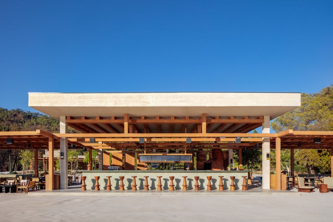Beach front Restaurant open sided, cybic architecture, Turkist Lycian culture , plateau roofline, bar stools against a blue sky| AHÃHA – Eco Luxury Design Hotel on Turkey’s Aegean Riviera  |The Aficionados 