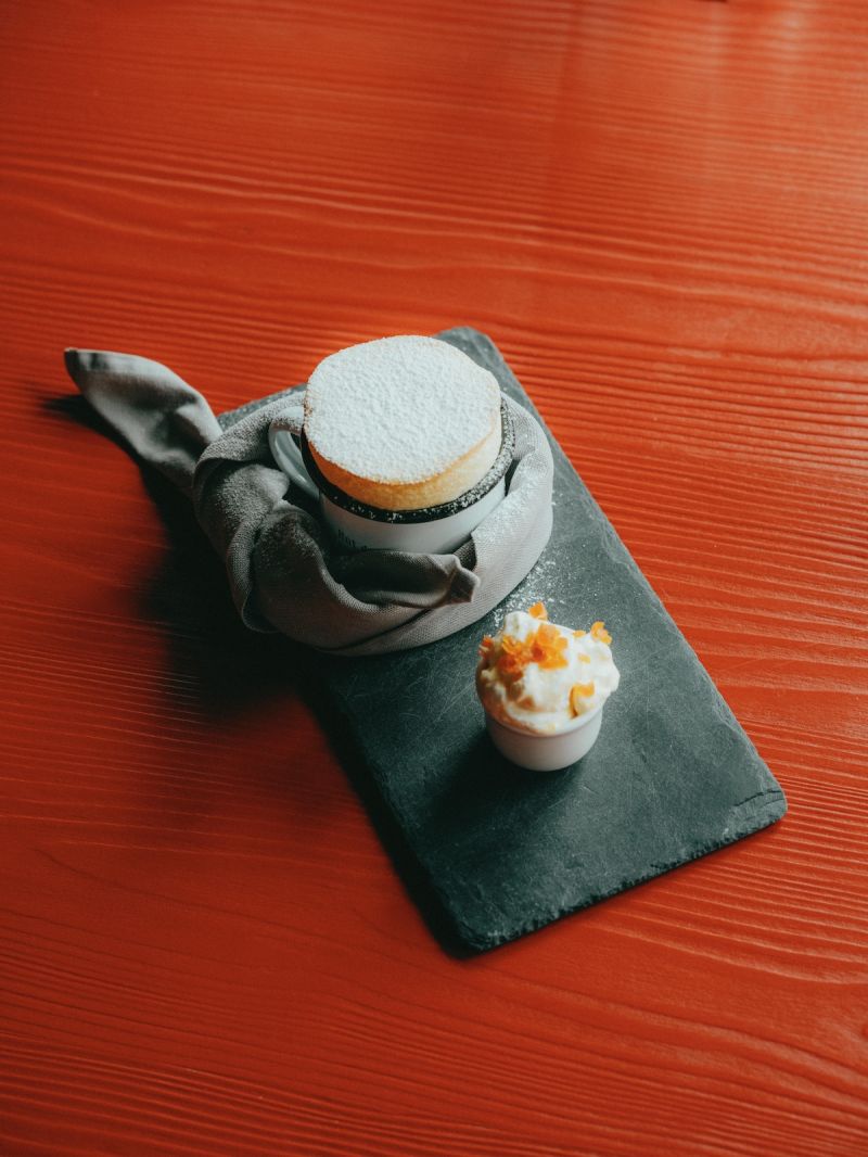 Redefining Alpine Cuisine | Soufflé served in the the Pan against a red background | The Grill Restaurant- Zermatt's Best Culinary Adventure at the Matterhorn