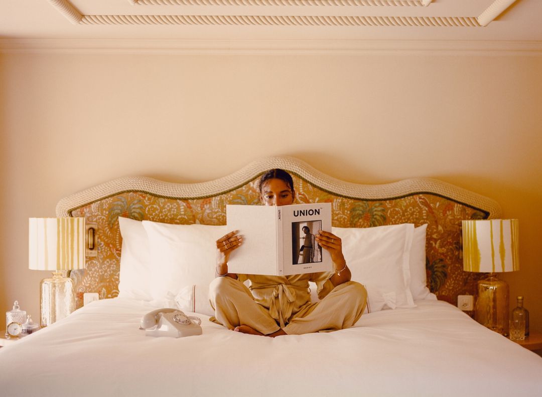 Luxury Design - person reading in bed holding a book | Beausite Boutique Hotel | Best Views of the Matterhorn in Zermatt