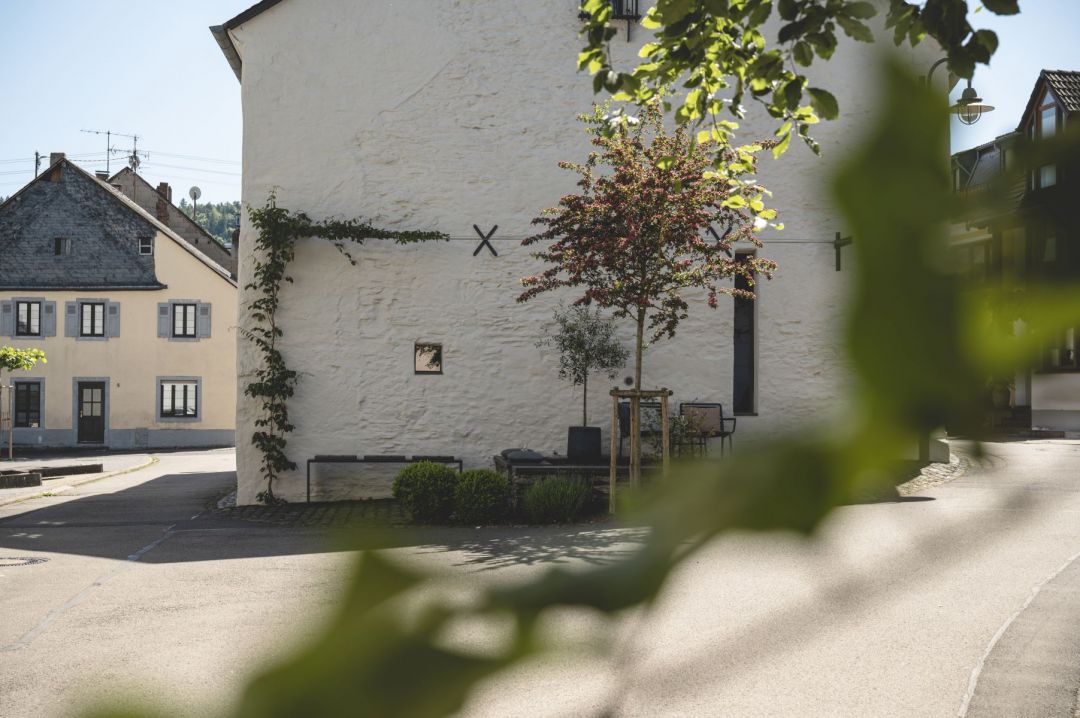 Restored 1723 lime-plastered Schieferhaus with black steel espalier and forecourt seating — Klara Rooms design holiday apartments, Trittenheim, Moselle Valley | The Aficionados 