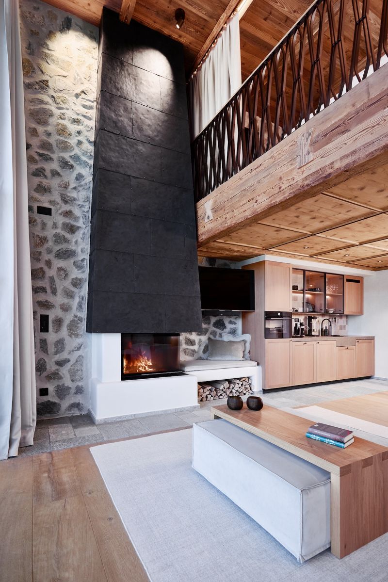 Tall black stone fire place - contemporary Alpine design interiors | BelArosa Chalet – Luxury All-Suite Design Hotel & Alpine Escape in Arosa | The Aficionados 