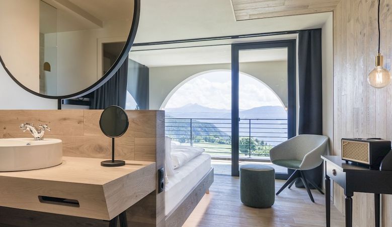 Gloriette Boutique Hotel Soprabolzano - Design Bedroom with arched windows designed by noa architects, overlooking the Dolomites in South Tyrol, Italy 