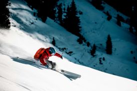 Skiier in red hitting the white piste | Kitzbühel Skiing Guide, World Cup Slopes and Alpine Flow in Austria