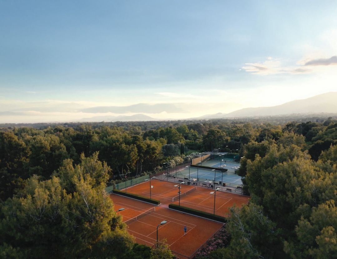 Aerial view of clay tennis courts in the pine forest at TATOÏ Club Athens | The Aficionados.com