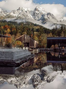 Larch-clad facade of Naturhotel Forsthofgut rising against the jagged limestone peaks of the Leogang Steinberge, the five-star forest hotel set into pine woodland in Leogang, Salzburger Land, Austria | The Aficionados.