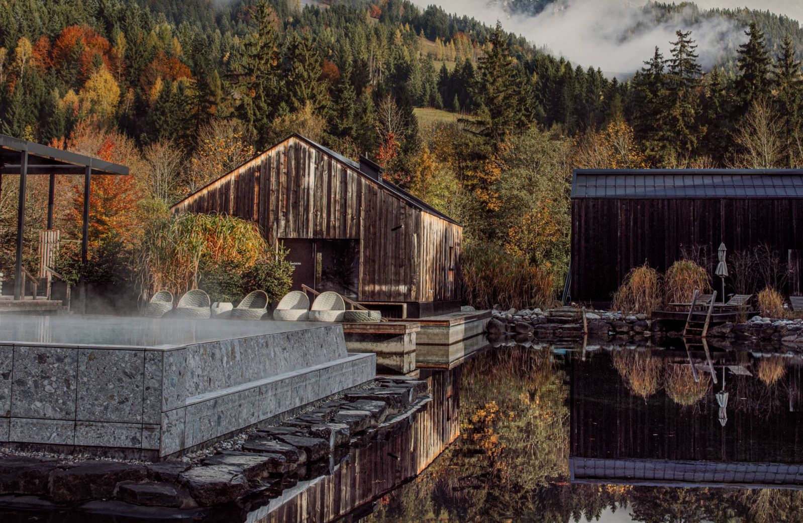 Larch-clad facade of Naturhotel Forsthofgut rising against the jagged limestone peaks of the Leogang Steinberge, the five-star forest hotel set into pine woodland in Leogang, Salzburger Land, Austria | The Aficionados.