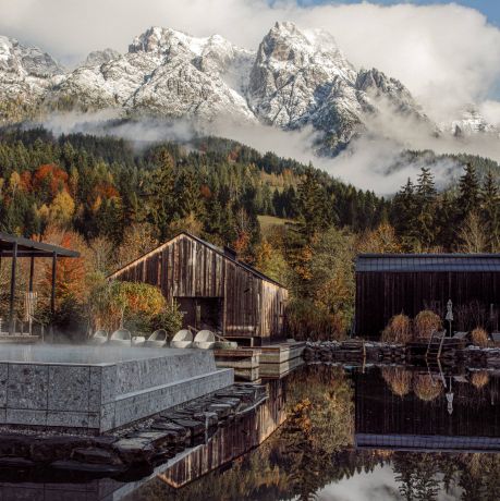 Larch-clad facade of Naturhotel Forsthofgut rising against the jagged limestone peaks of the Leogang Steinberge, the five-star forest hotel set into pine woodland in Leogang, Salzburger Land, Austria | The Aficionados.