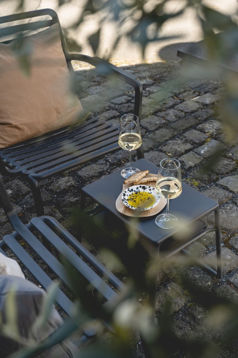Two glasses of Moselle Riesling with bread and olive oil on black steel table, cobblestone forecourt — Klara Rooms boutique apartment, Trittenheim, Middle Moselle Germany