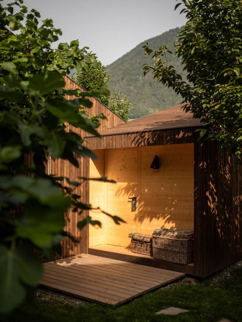 Wodden cabin in forest and vines - illuminated in yellow glow lighting | Hotel Schwarzschmied Best Wellness and Design Retreat in South Tyrol | The Aficionados 