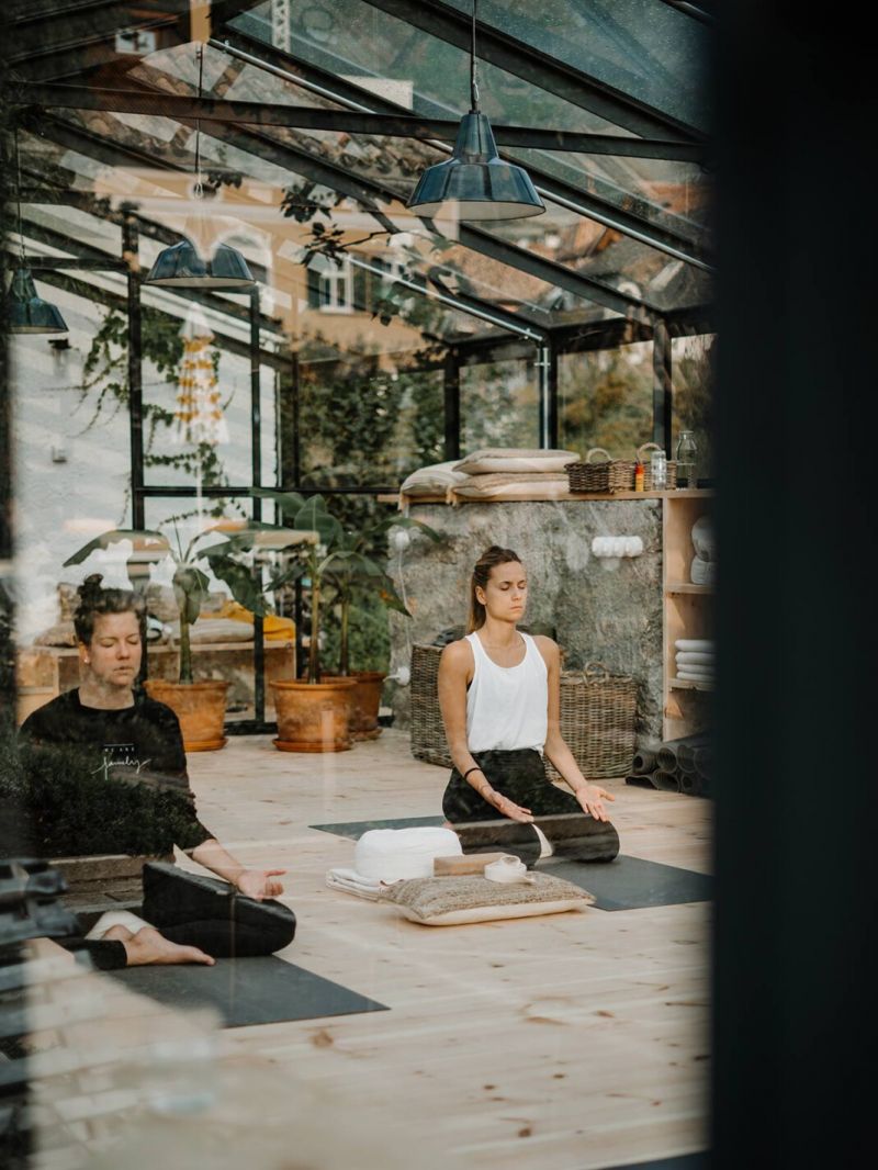 Two females at Yoga sitting on mats | Hotel Schwarzschmied Best Wellness and Design Retreat in South Tyrol | The Aficionados 
