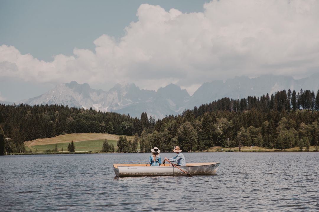 Boating on Lake Schwarzsee Kitzbühel | Tow people sitting o the lake Hotel Seebichl, Kitzbühel, Tyrol – Design Retreat by Lake Schwarzsee, Austria, The Aficionados 
