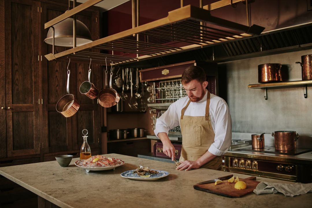 Chef At work in the Country Farmhouse Style Kitchen designed by Edinburgh-based Laurence McIntosh, architectural joinery  | Aldourie Castle Loch Ness | Historic Private-Hire Luxury Estate in Scotland 