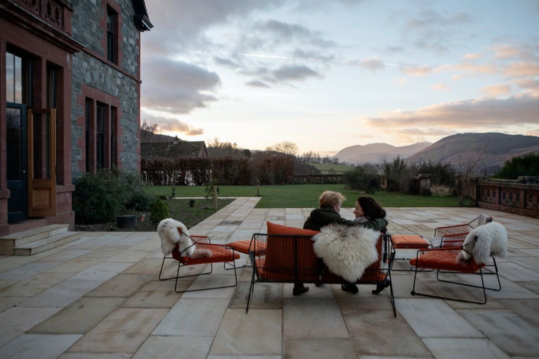 Susie and John sitting on the terrace | Luxury Self Catering Design Lodge in Scotland – A Chic Escape with Epic Views Perthsihre in the Dun Aluinn Estate 