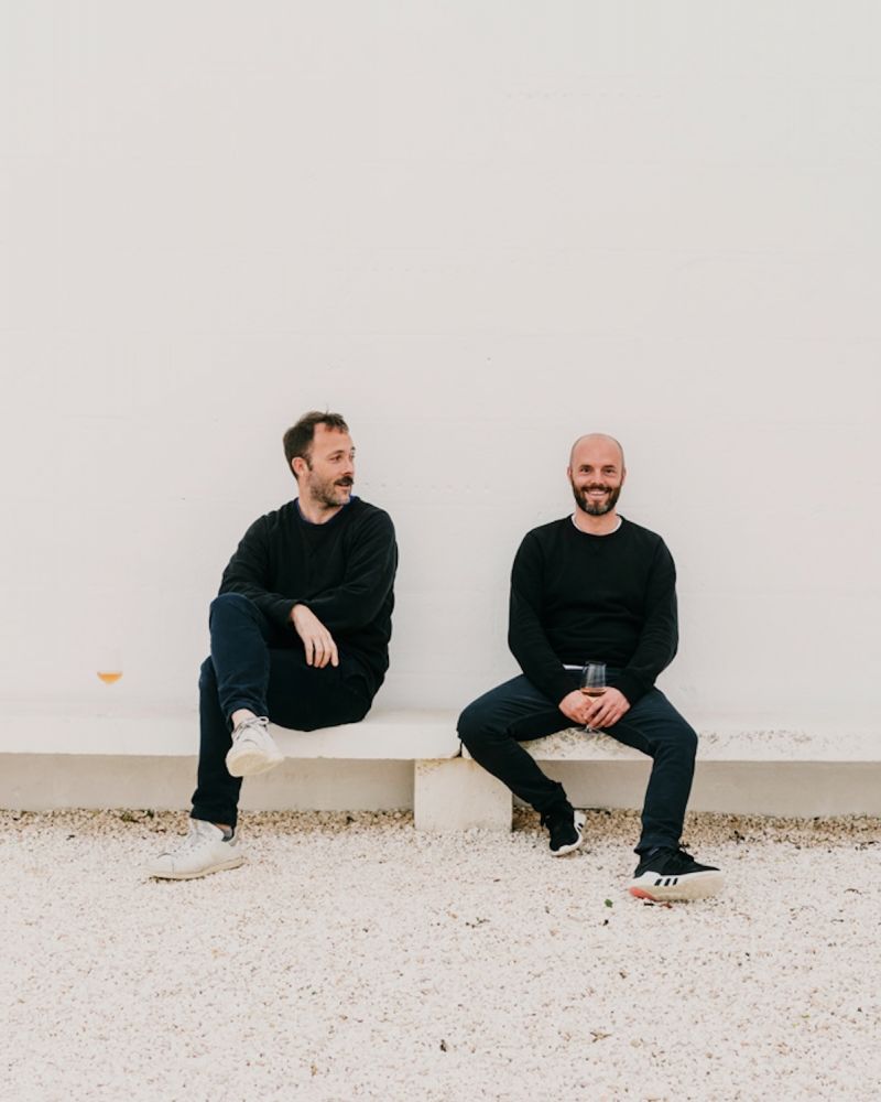 Owner Carlo Lanzini and architect Andrew Trotter on a concrete bench against a limewashed wall at Masseria Moroseta, Ostuni, Puglia | The Aficionados.