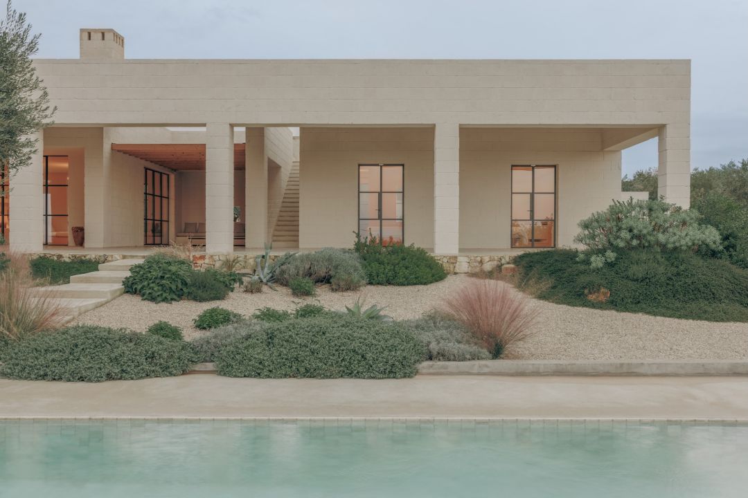Earth-toned colonnade and pool of Casa Maiora, a Studio Andrew Trotter villa set in a drought-tolerant gravel garden near Carovigno, Puglia | The Aficionados.