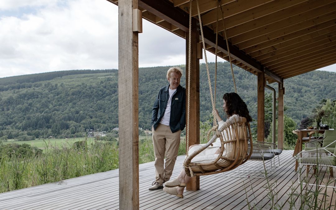 Couple sitting on the verandah |Luxury Self Catering Design Lodge in Scotland – A Chic Escape with Epic Views Perthsihre in the Dun Aluinn Estate 