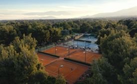 Aerial view of clay tennis courts in the pine forest at TATOÏ Club Athens | The Aficionados.com