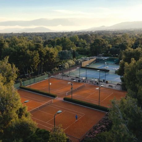 Aerial view of clay tennis courts in the pine forest at TATOÏ Club Athens | The Aficionados.com