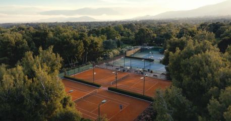 Aerial view of clay tennis courts in the pine forest at TATOÏ Club Athens | The Aficionados.com