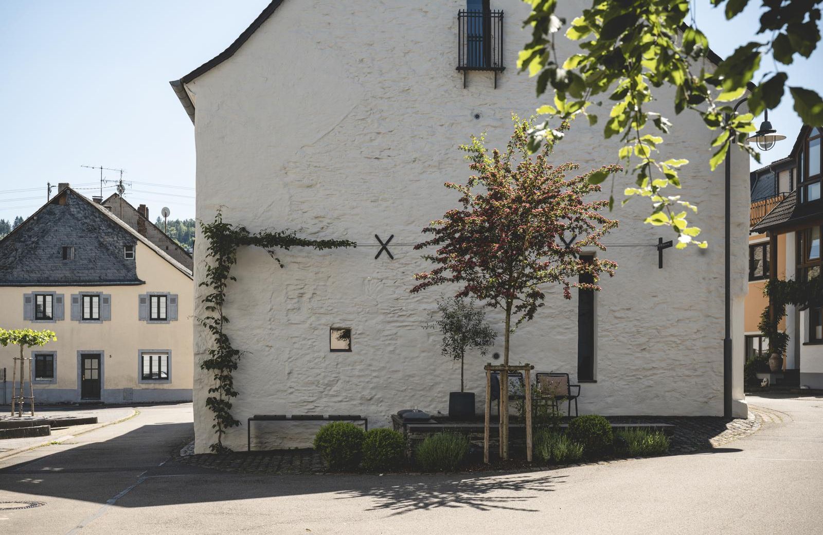 Restored 1723 lime-plastered Schieferhaus with black steel espalier and forecourt seating — Klara Rooms design holiday apartments, Trittenheim, Moselle Valley | The Aficionados 