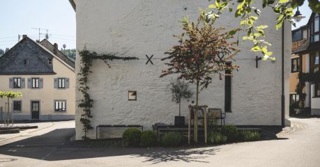 Restored 1723 lime-plastered Schieferhaus with black steel espalier and forecourt seating — Klara Rooms design holiday apartments, Trittenheim, Moselle Valley | The Aficionados 