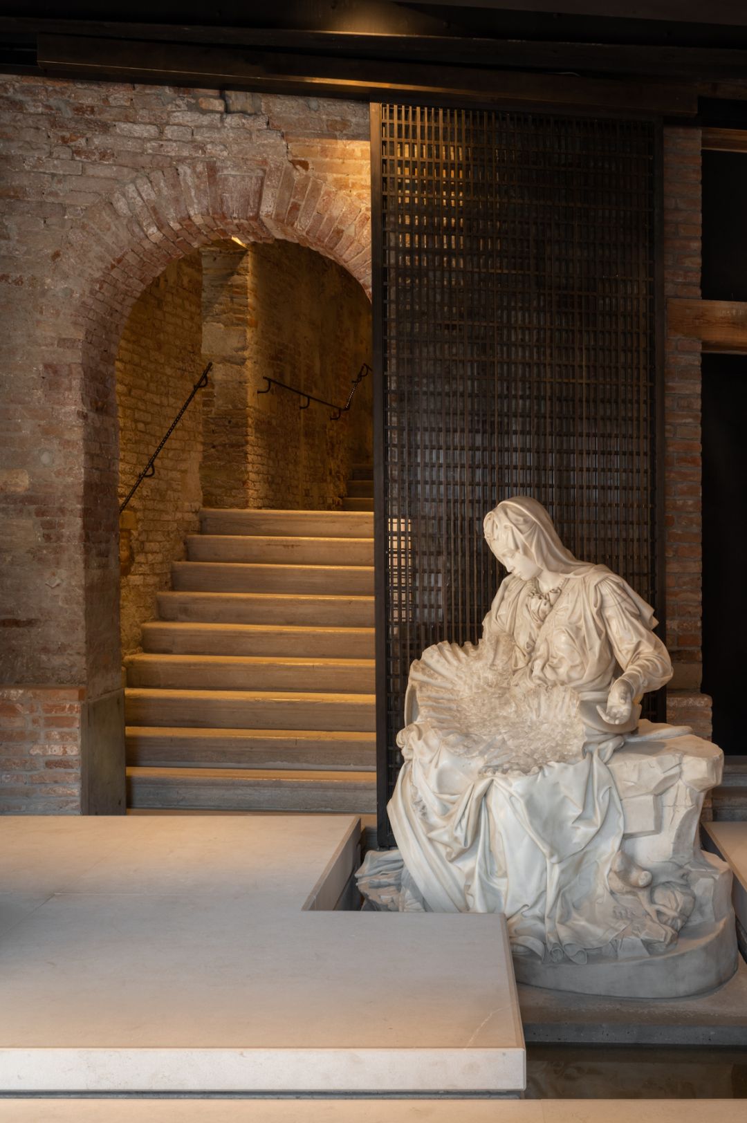 Classic Statue in white marble against a dark moddoy brouwn brick entrance of Venice Venice Hotel, Italy | Pantone's Mocha Mousse: Warmth of Design, Travel and Colour-led Hotel Style