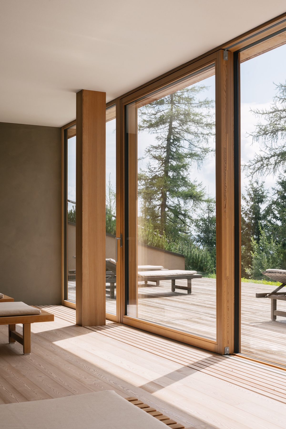 Architecture by Matteo Thun | Large larch frammed window doors looking over the trees | vigilius mountain resort: Holistic Design & Spa Retreat in South Tyrol