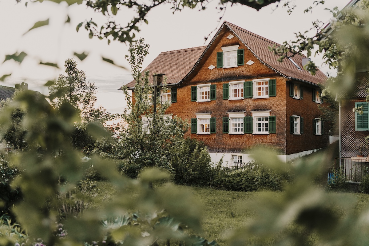 Typical Bregenzer style village house with gable roof and shutters in green | Mesmerhaus |Raw Heritage Retreats: Design-Led Hideaways & Nature Sanctuaries Across Europe