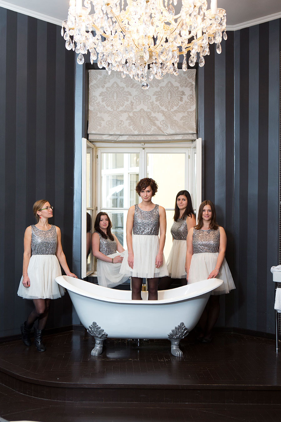 Hote staff posed in front of the freestanding bathtub , overhead chandelier |Otto & Co: The Story of Hotel Altstadt Vienna | Otto, Saskia & Lisa Wiesenthal