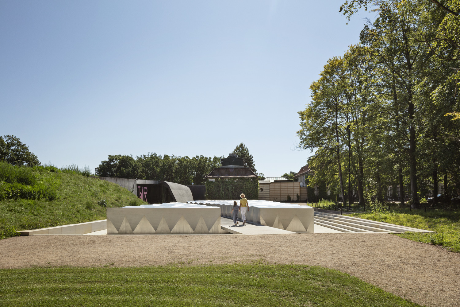 Snøhetta’s low pale entrance to the underground extension at Ordrupgaard, ramps and steps sunk into the garden, with Zaha Hadid’s wing and the 1918 house behind | The Aficionados