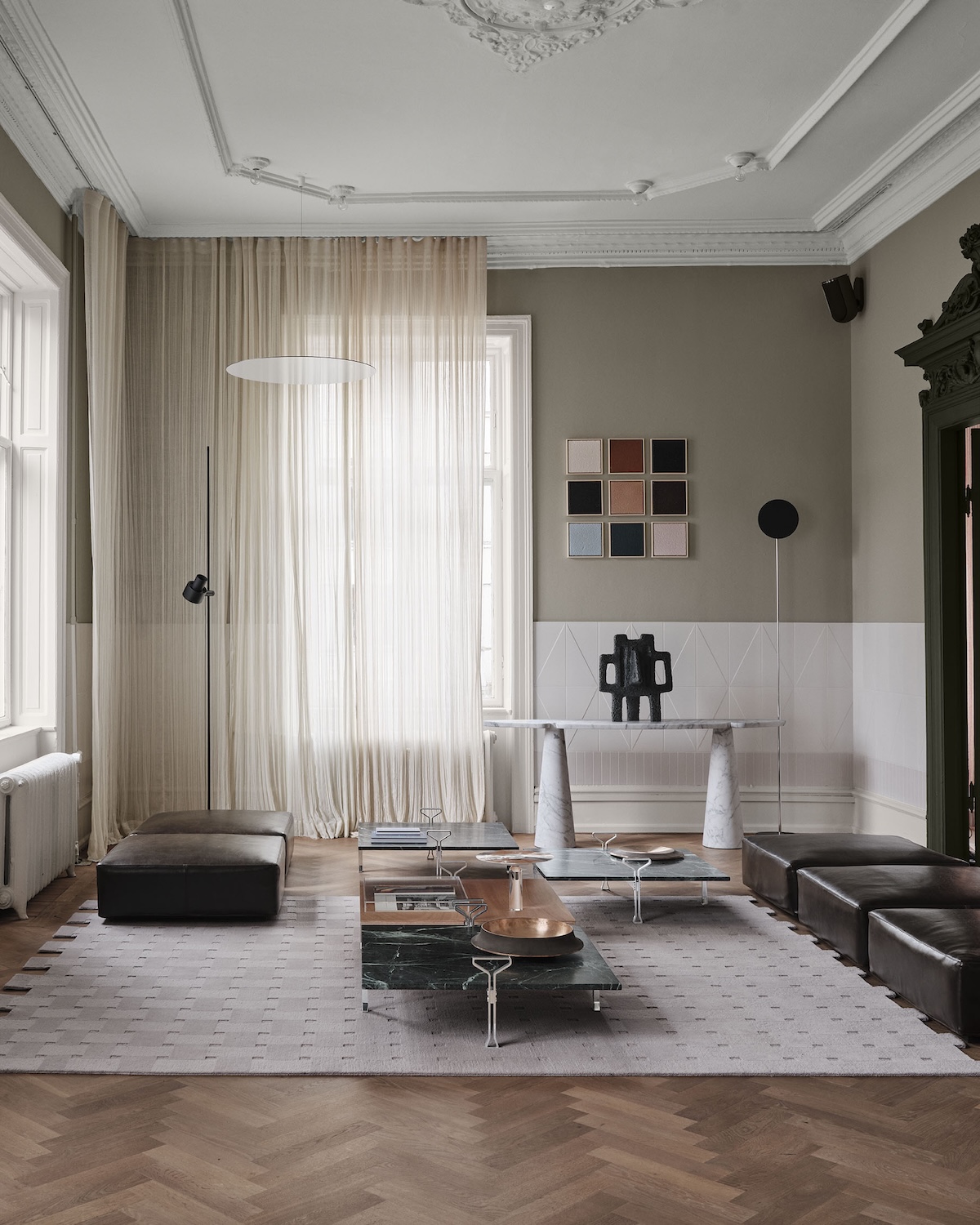 Artistic Position in Space living room by Agape and Agapecasa at 3daysofdesign: low Schwob Tables in green marble with side handles, black leather ottomans and a white marble Eros console beneath framed File Under Pop colour swatches.