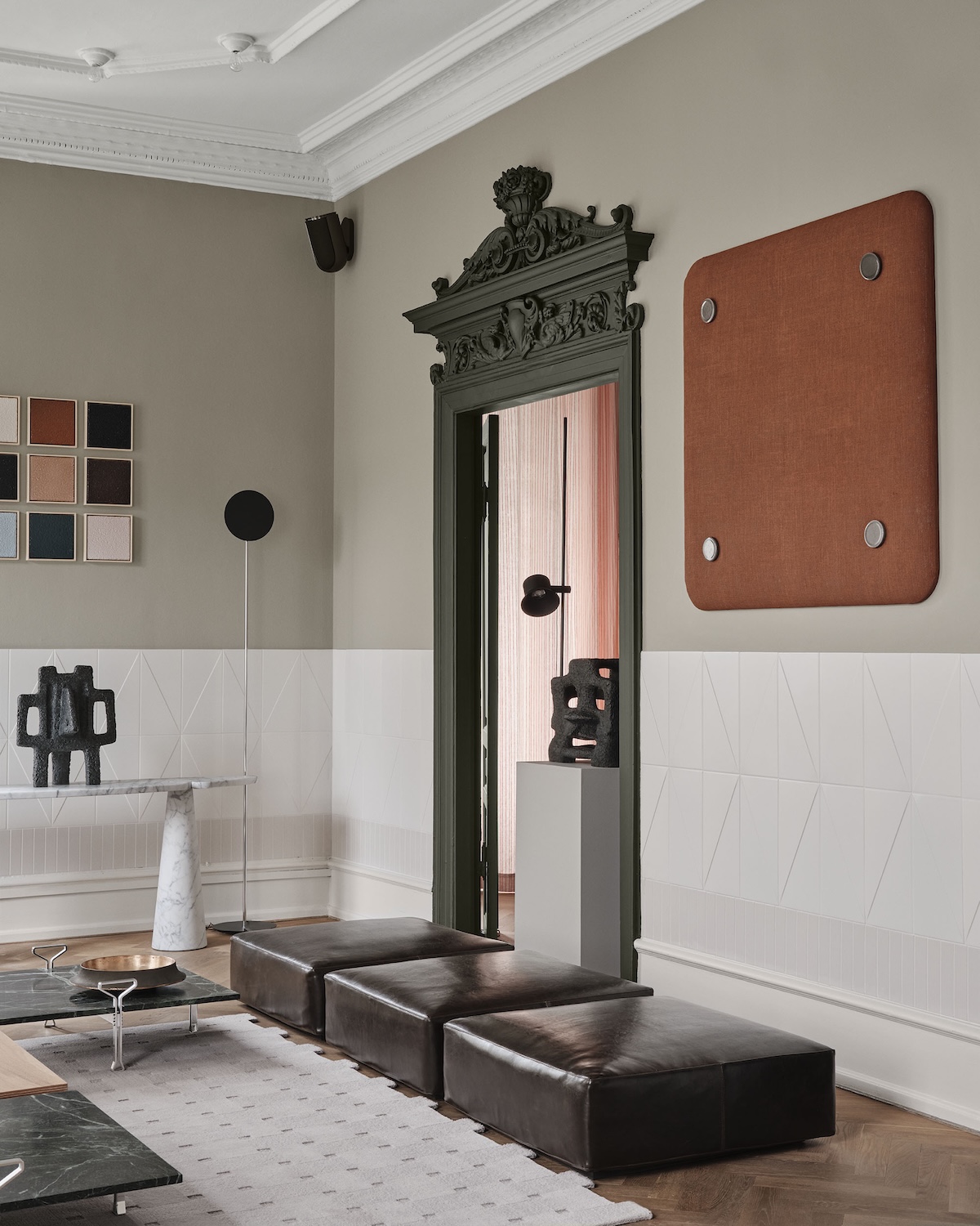 Artistic Position in Space corner by Agapecasa: white marble Eros console with black Sonja Ferlov Mancoba sculptures, black leather ottomans and a carved green mirror surround.