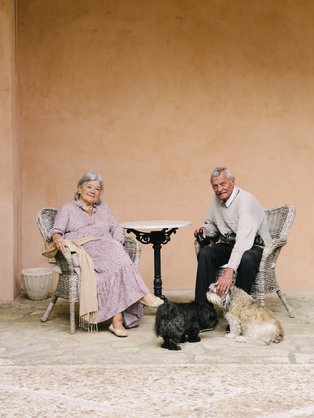 Joan Miró and Pilar Juncosa seated with their dogs in wicker chairs at their home in Cala Major | The Aficionados