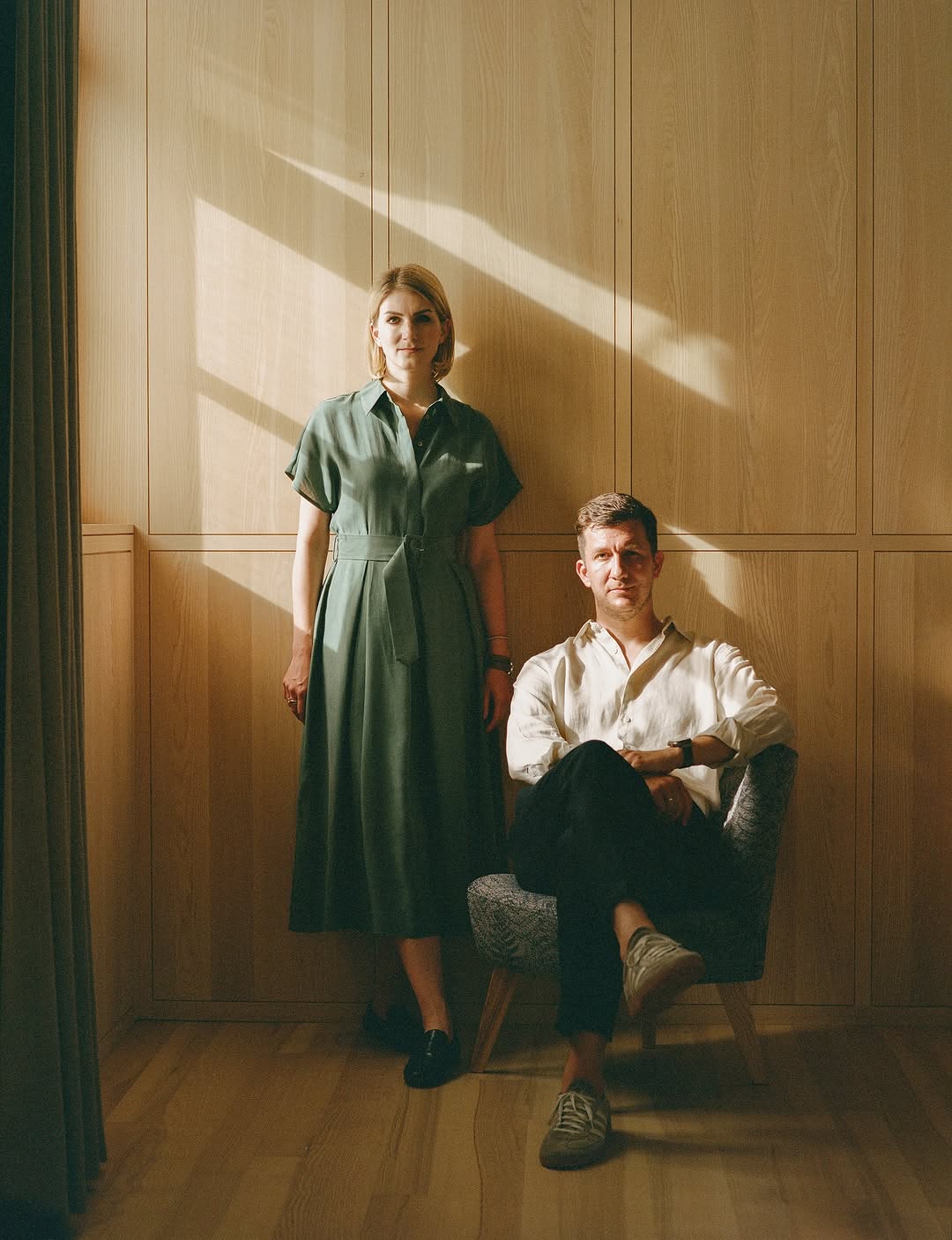 Peter & Pai Fezt - sitting against a timber background at Hotel Hirschen in Schwarzenberg Bregenzerwald, Austria | Family Ties & Design Minds – Hotels, Style & Flavour Shaped by Kinship