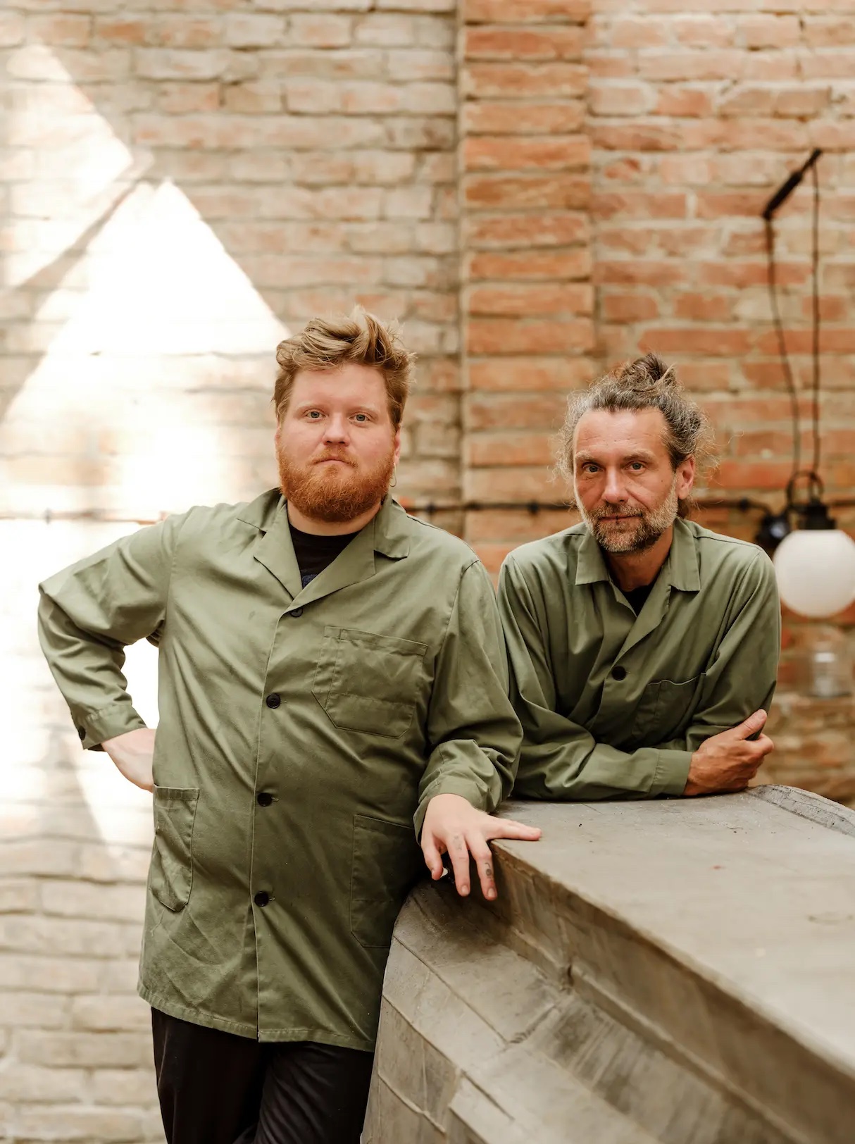 Mraz and Son. Chefs stnading agains t a brick wall at their Viennese Restaurant | Family Ties & Design Minds – Hotels, Style & Flavour Shaped by Kinship