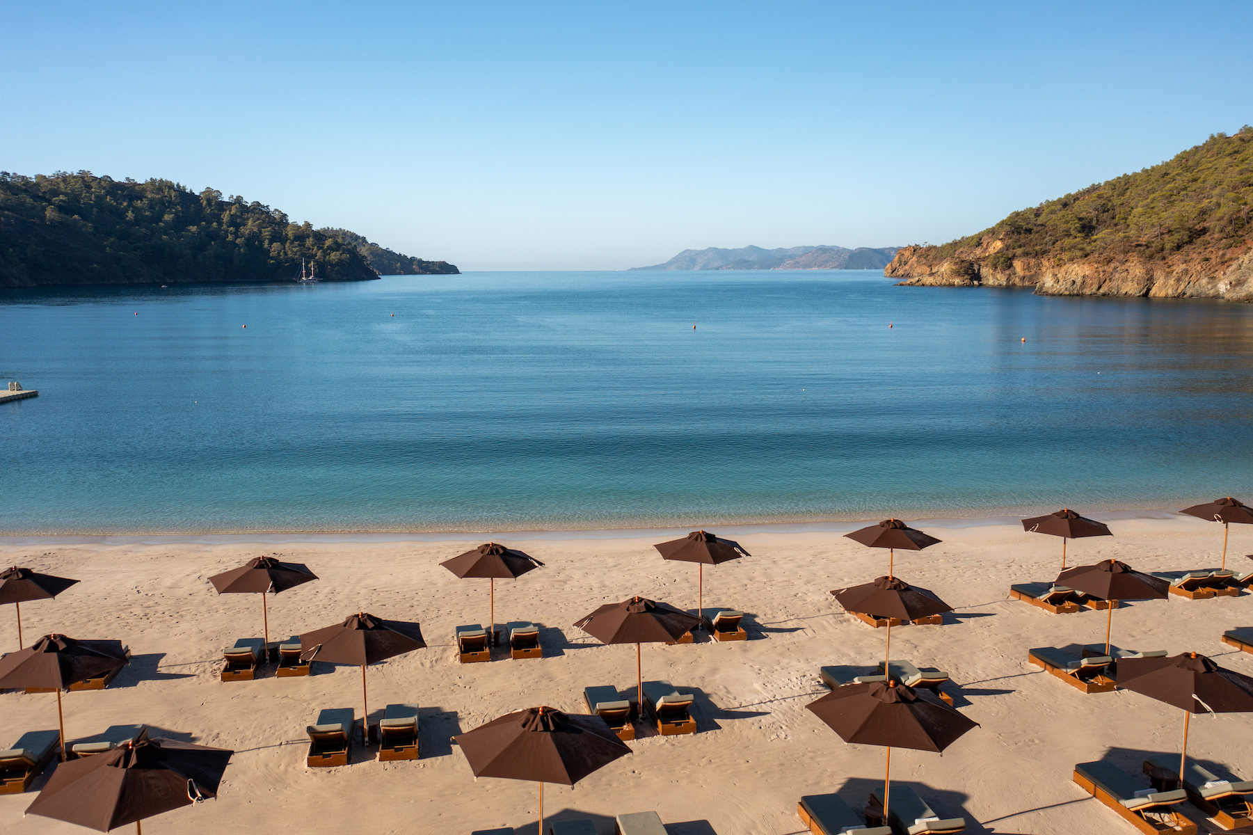 Beach Scene Summer Holidays - rows of umbrellas few, secluded cove |Günlüklü Bay: Türkiye’s Hidden Forested Cove of Natural Luxury