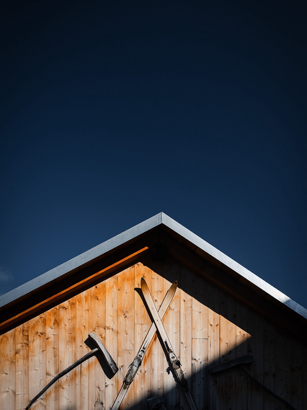Pitched wooden rooftop with a pair of Ski attatched to the eaves | Gion A. Caminada Alpine Architecture in Switzerland