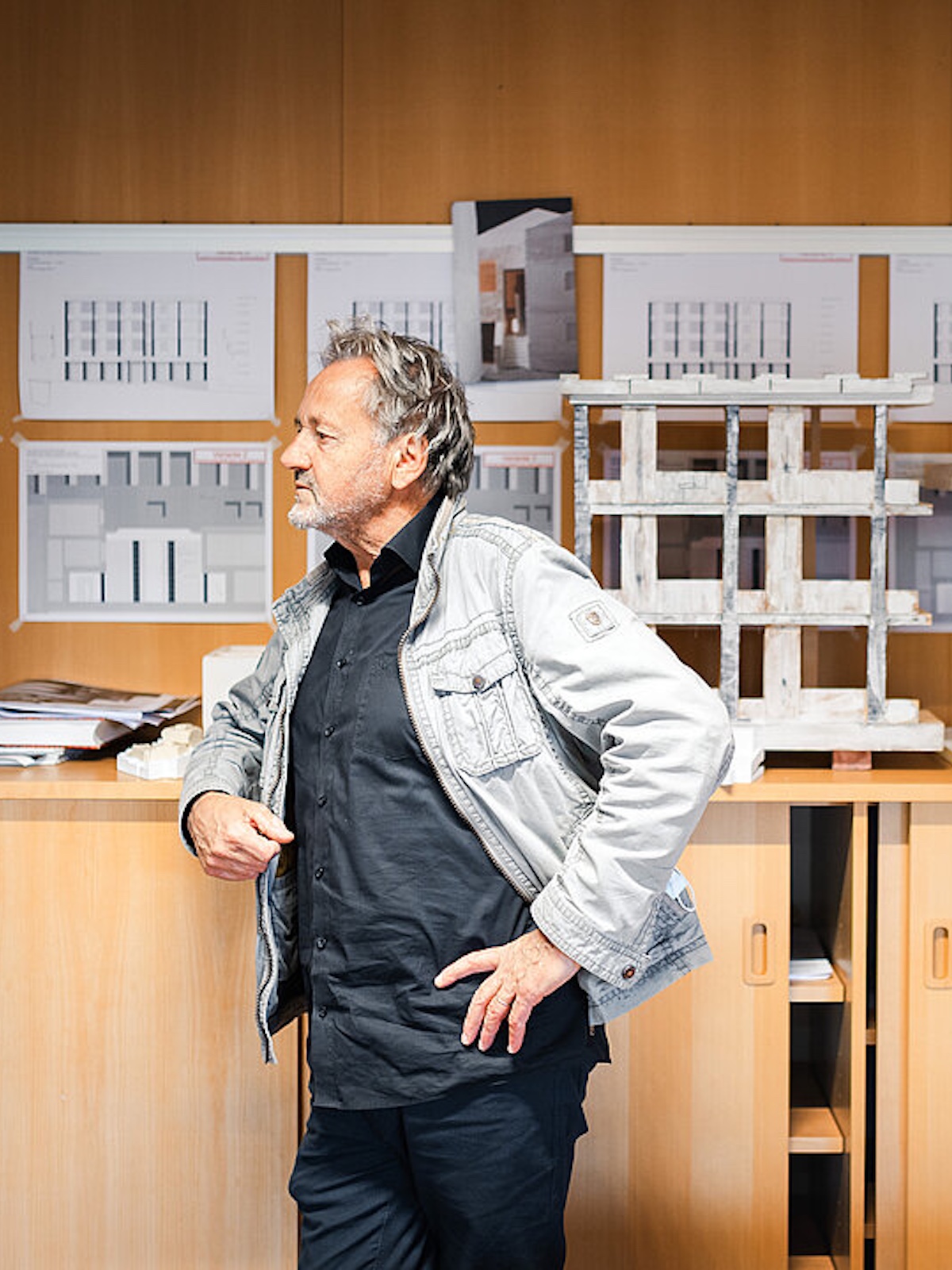 Man, Gion A. Caminada Stnading in front of architectural blueprints | Alpine Architecture in Switzerland
