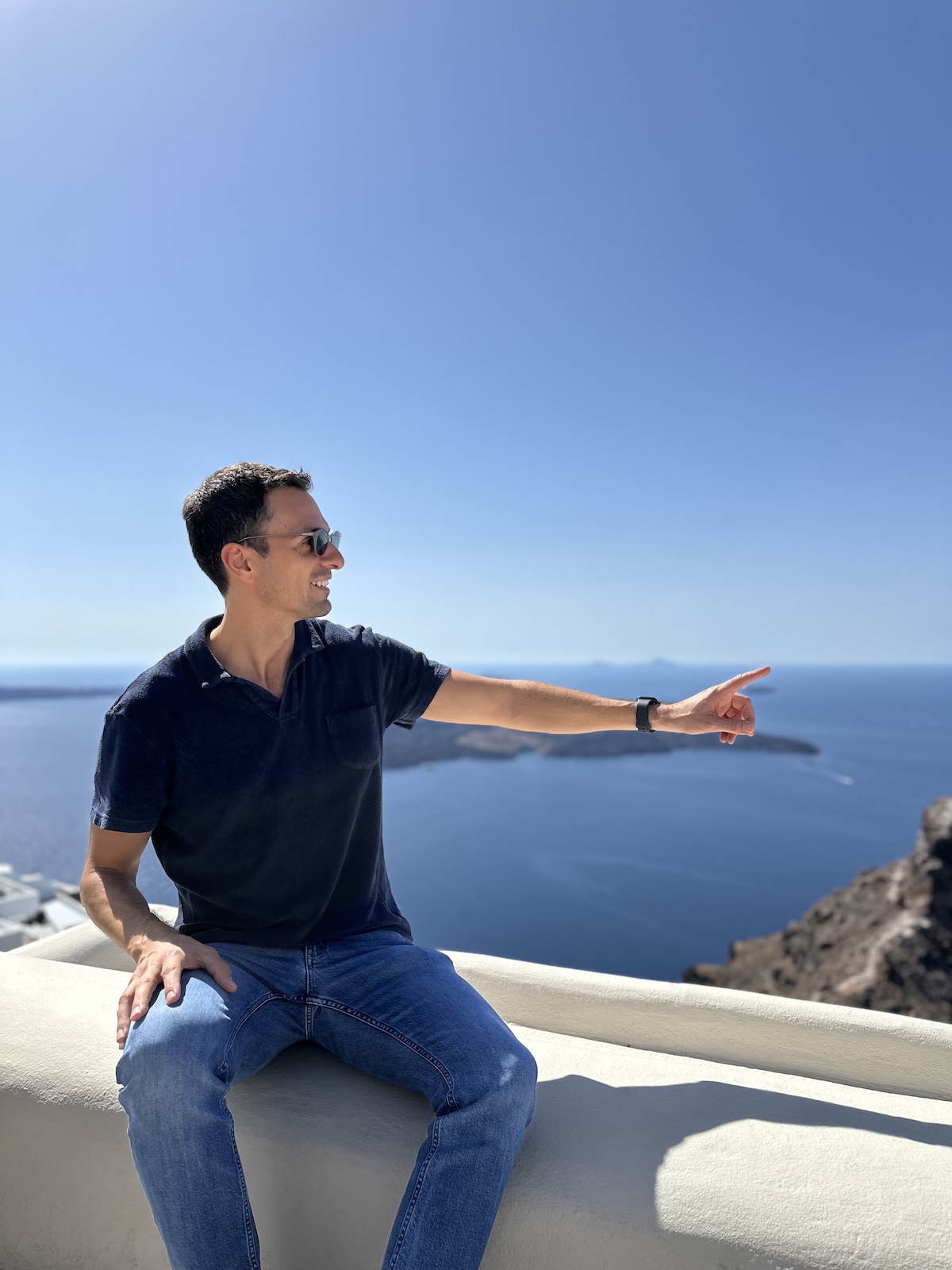 Dimitris Kossyfas, Chief Commercial Officer HOPER Greeces First Helicopter Airline. Greek man sitting with an agean sea veuw behind him pointing towards a new destination in the Greek islands 
