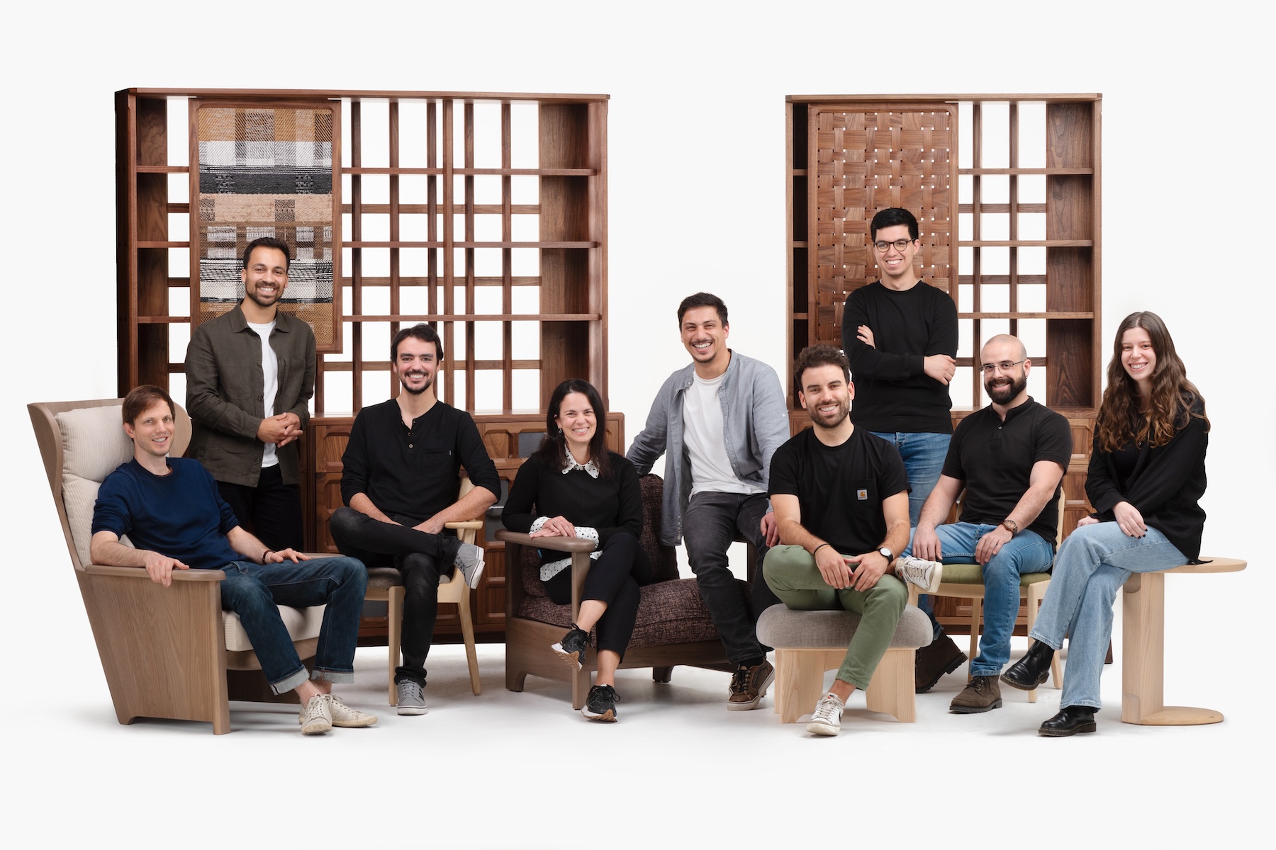The De La Espada Atelier team photographed among solid walnut shelving units and lounge chairs | The Aficionados