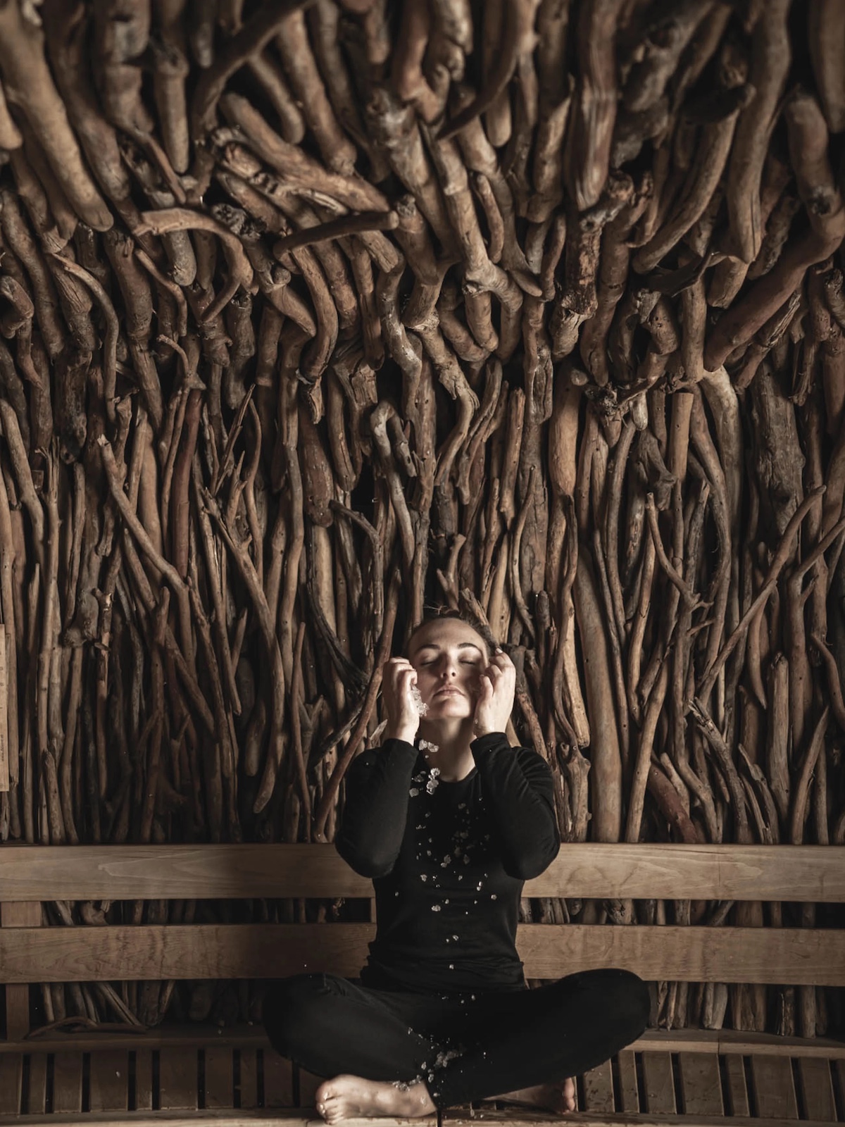 Woman sitting in a spa created by driftwood | Engel Spa Austria: Wellness Retreat in the Austrian Alps with Design Soul