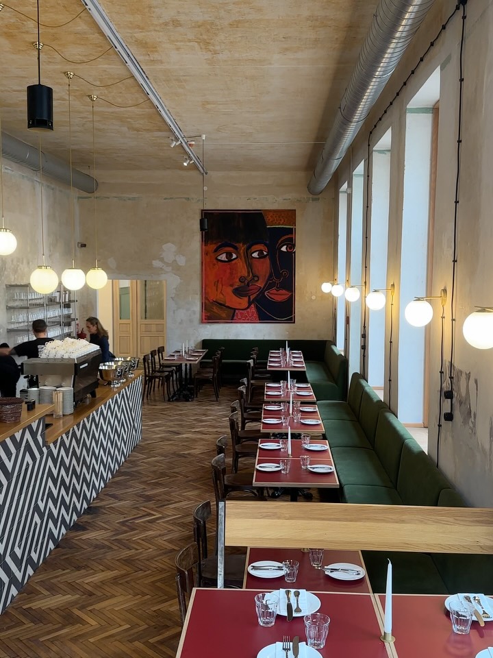 Dining room at Donauhof, Vienna, with green banquette seating, oxblood tables and a zigzag-tiled bar