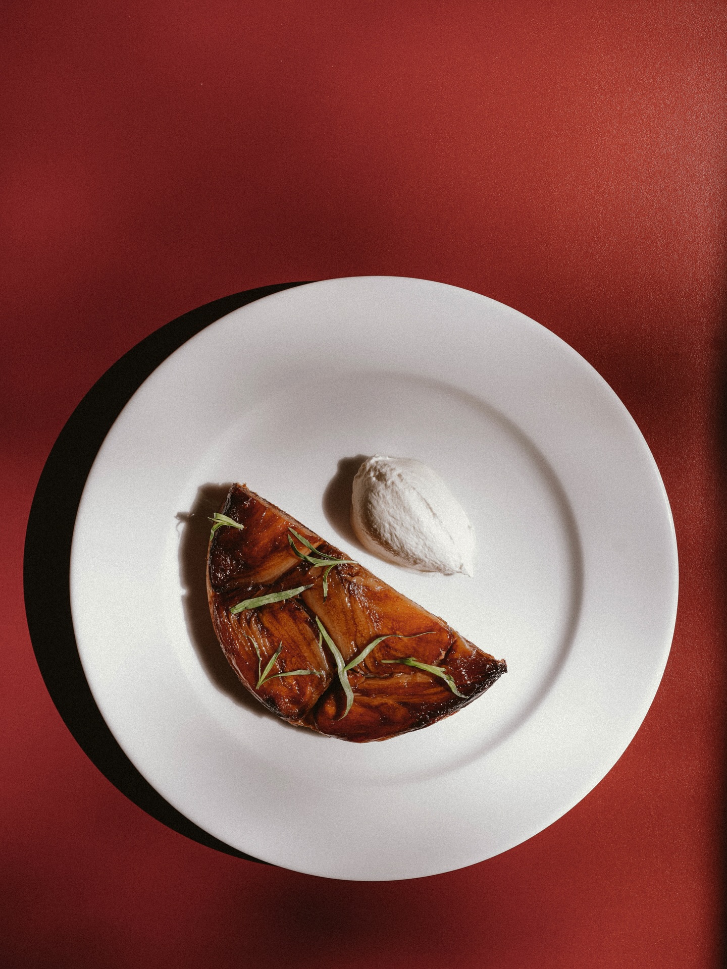 Tarte tatin with tarragon and a quenelle of cream, served at Donauhof
