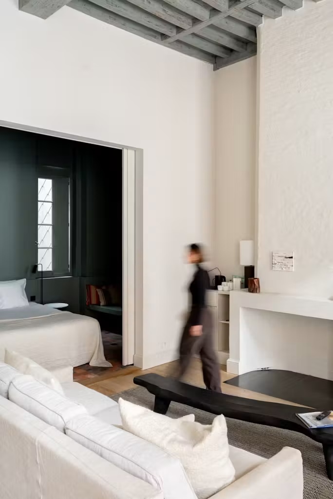 White linen suite with sliding door to a dark bedroom at August, Antwerp | The Aficionados
