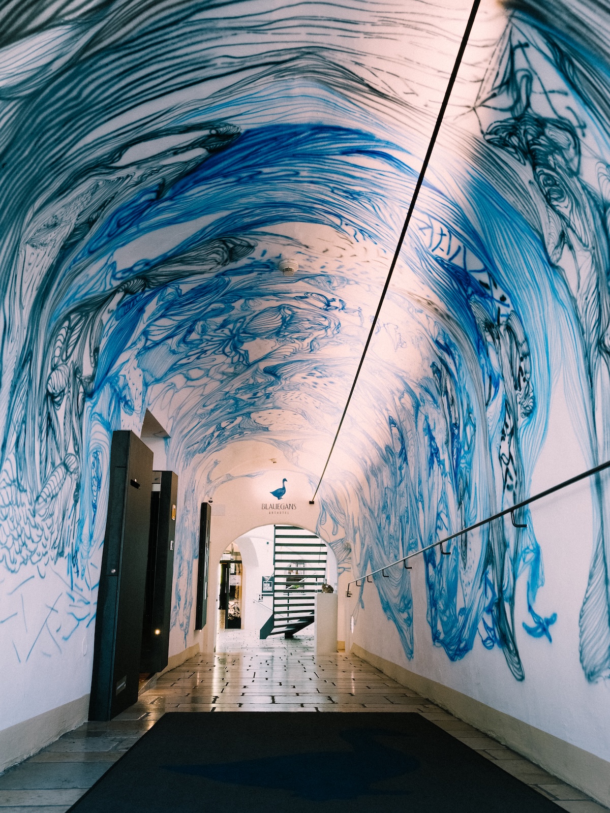 Music-inspired mural lining the passage to the guest quarters at the Arthotel Blaue Gans | The Aficionados
