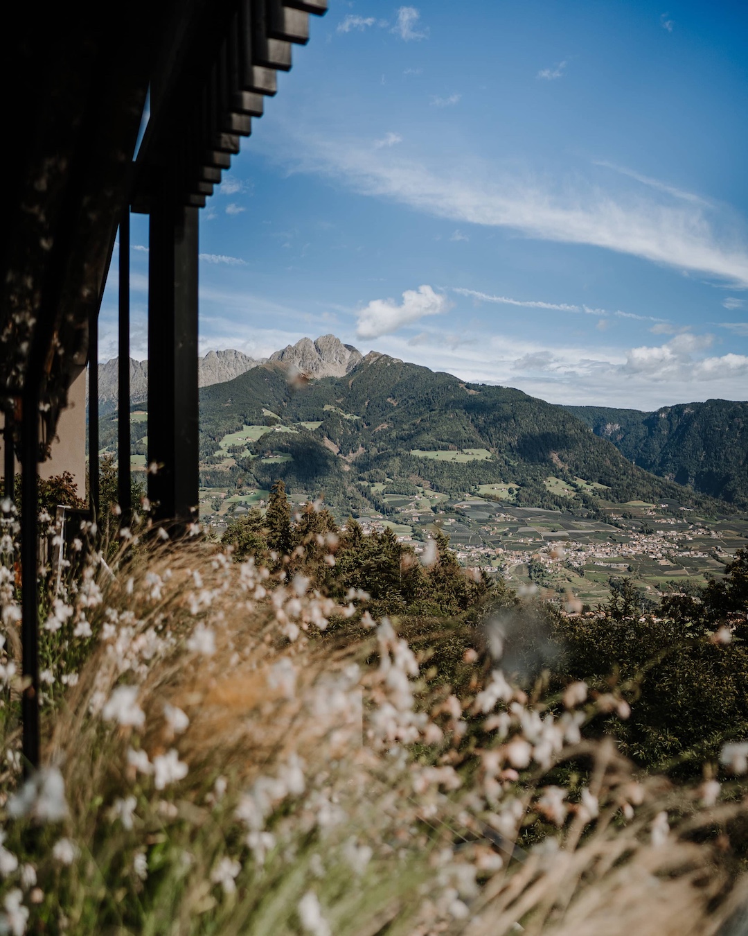 View from the side angel o fthe house, showcasing fabulously green lush meadows looking up towards the mountains | Raw Heritage Retreats: Design-Led Hideaways & Nature Sanctuaries Across Europe