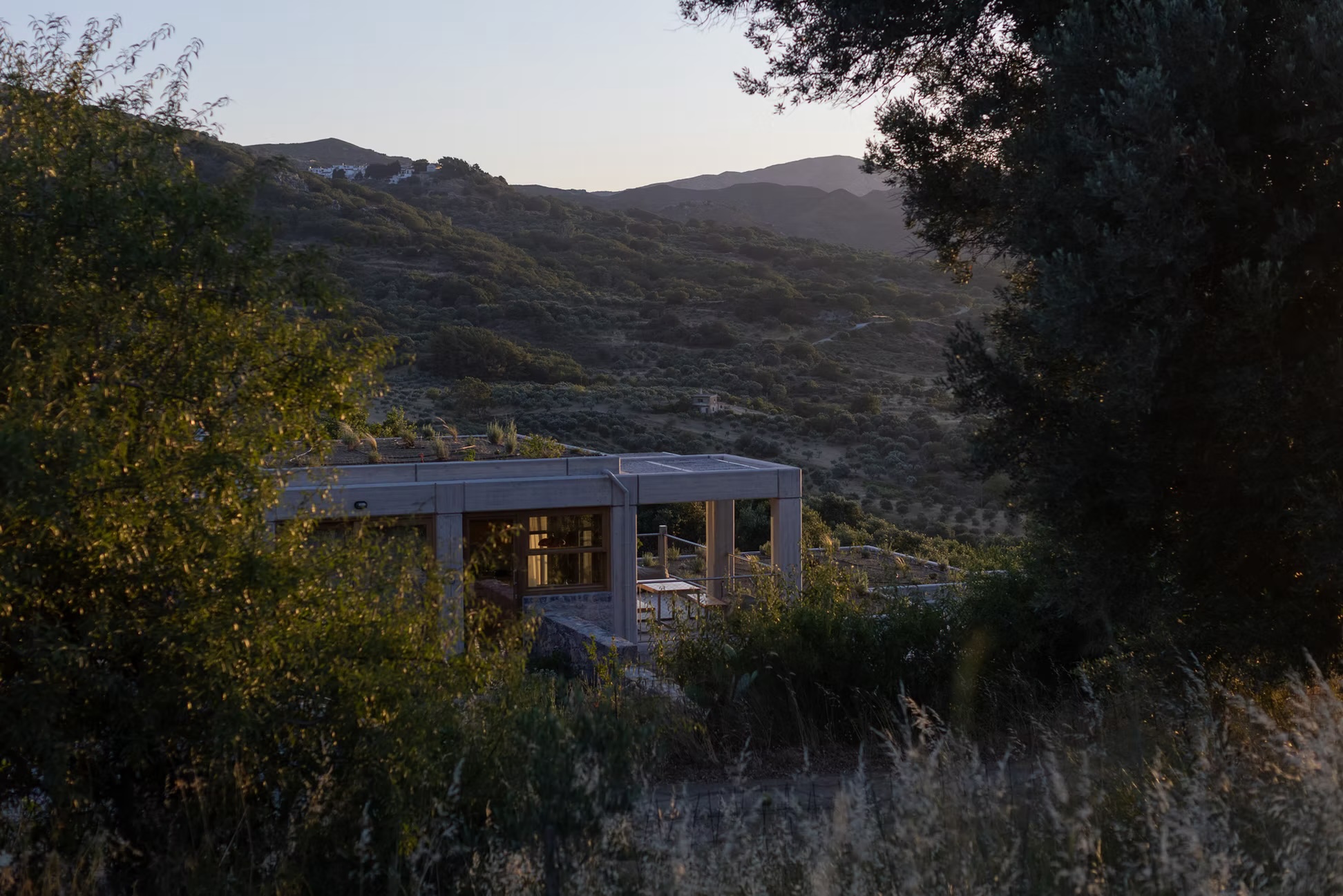 A Meraki Studios apartment with its green roof set into the hillside at golden hour, central Crete | The Aficionados
