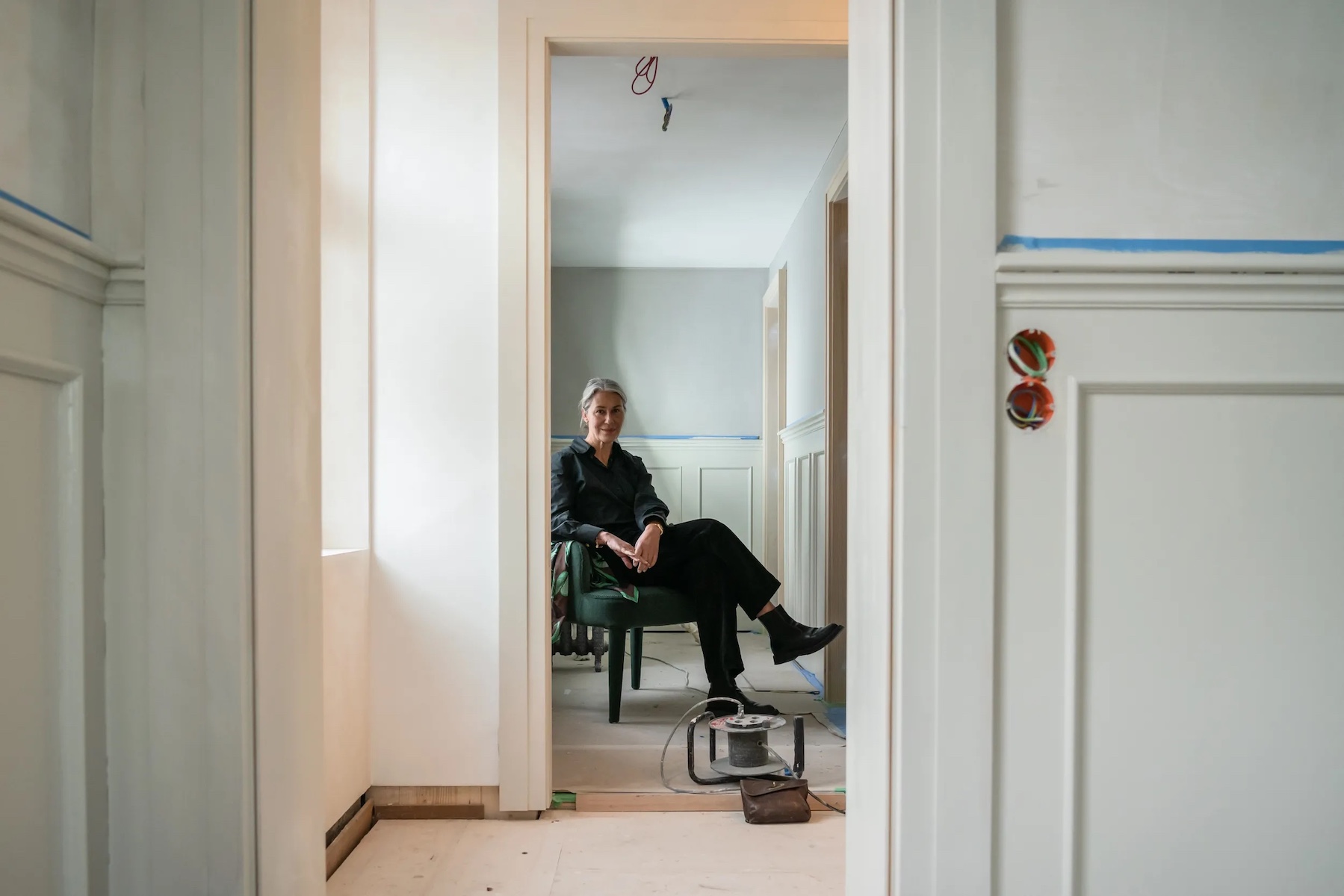 Rtuh Kramer sitting on a chair contemplating her design narratives in a restoration project. |Ruth Kramer: Interior Designer Behind Brücke 49 & Wildland