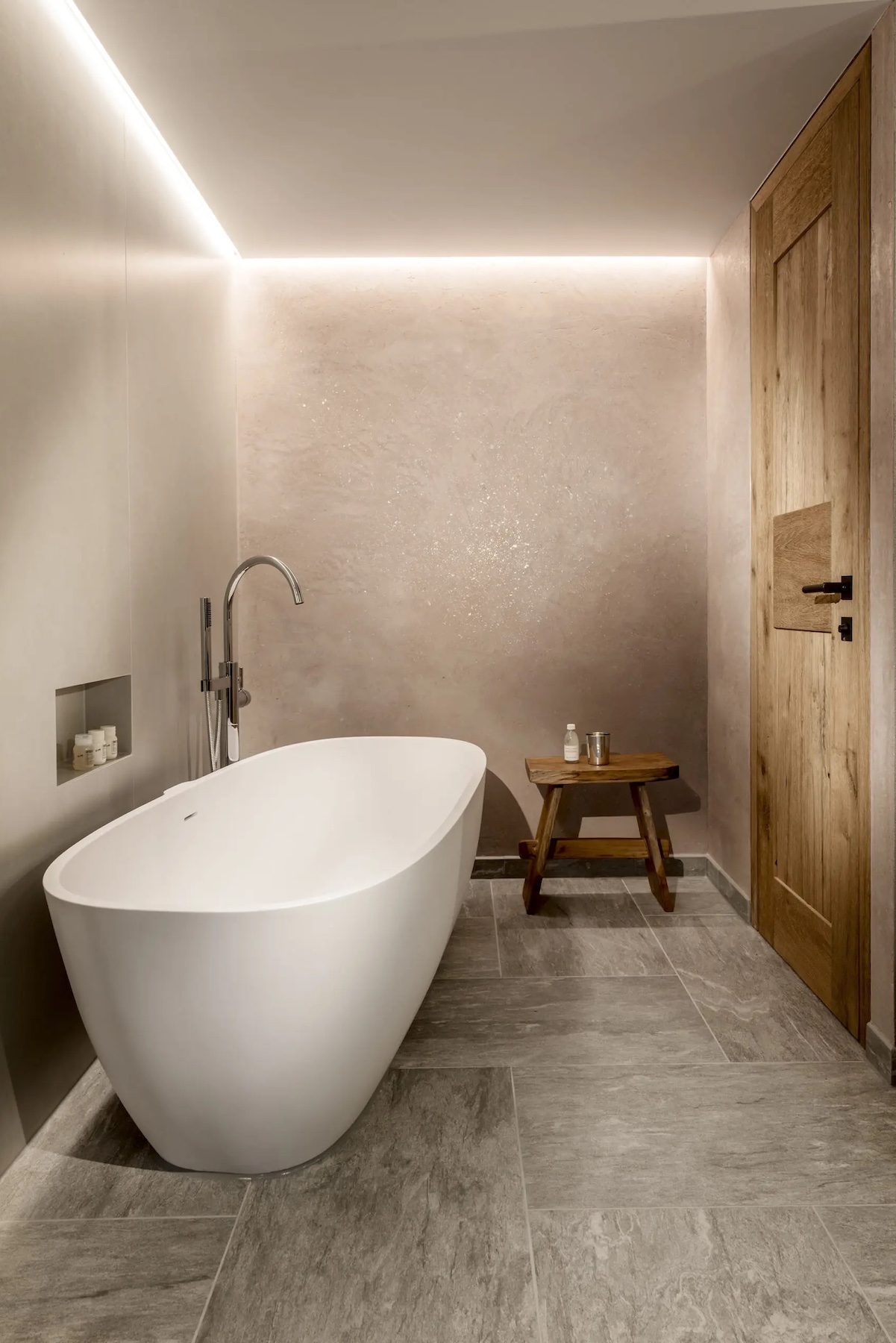 Hotel Arlberg Lech Austria - Luxury free standing bath tub in the suites, white tub with natural stone flooring |Agape: Sculptural Bathroom Design Across Iconic Hotels | The Aficionados 